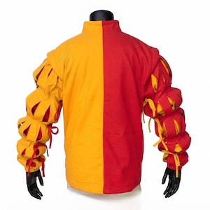 Peut inclure: Une veste &agrave; manches longues pr&eacute;sentant un design divis&eacute; avec un c&ocirc;t&eacute; gauche jaune uni et un c&ocirc;t&eacute; droit rouge uni. Les manches sont construites avec de multiples fentes horizontales r&eacute;v&eacute;lant une couche int&eacute;rieure contrast&eacute;e, fix&eacute;es par des liens.