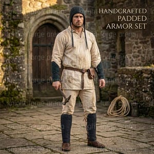May include: Handcrafted padded armor set. The ensemble includes a hooded shirt, pants, and leg armor in beige. The set features a brown belt, a small pouch, and black padded arm and leg guards. The image also shows a hammer.
