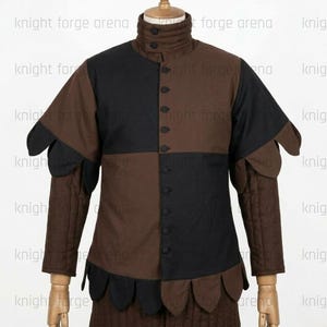 Peut inclure: Un pourpoint marron et noir dot&eacute; d'un col montant &agrave; deux boutons, d'une fermeture boutonn&eacute;e sur le devant et de manches longues. Le v&ecirc;tement pr&eacute;sente un motif &agrave; carreaux sur le torse et des bords festonn&eacute;s aux &eacute;paules et &agrave; la base.