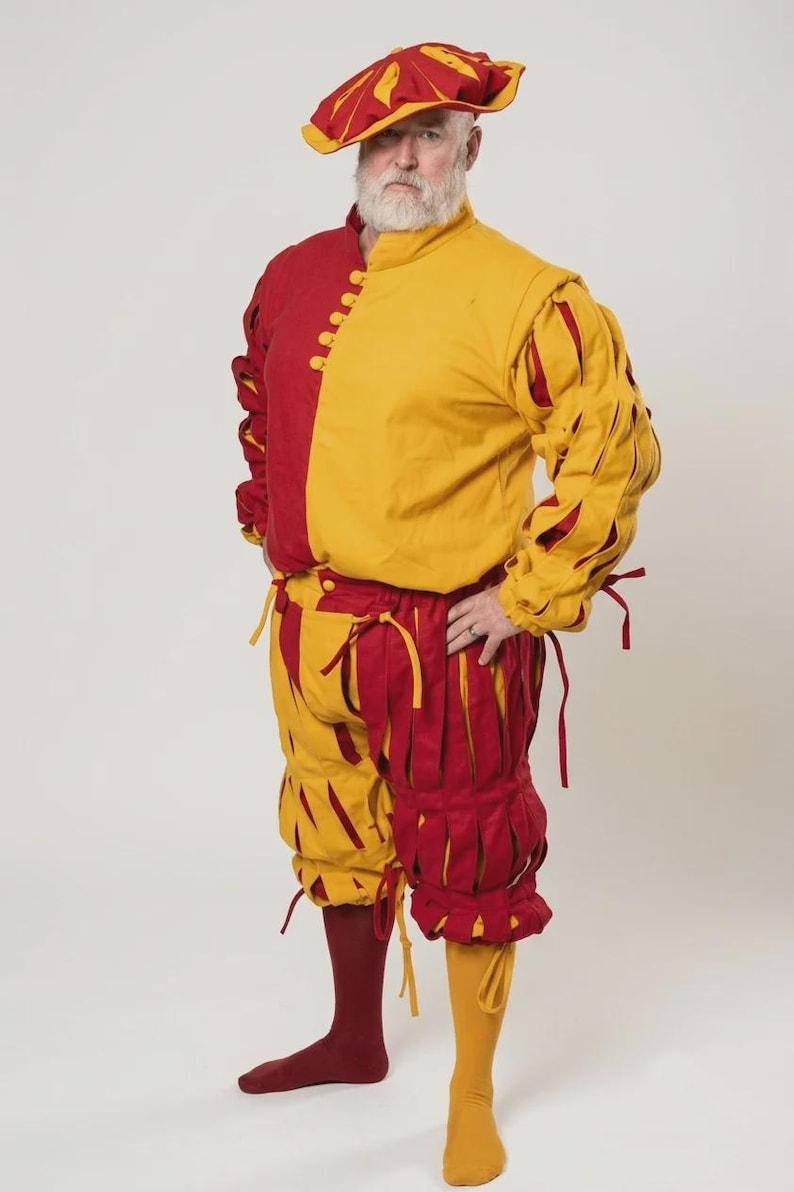 Peut inclure: Un pourpoint rouge et jaune &agrave; col montant et fermeture boutonn&eacute;e, associ&eacute; &agrave; une culotte fendue assortie avec des d&eacute;tails &agrave; nouer. La tenue comprend un b&eacute;ret rouge et jaune coordonn&eacute; ainsi que des bas unis de couleur rouge et jaune.