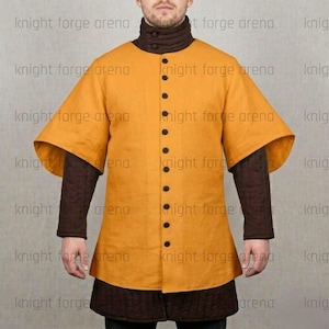May include: Mustard yellow medieval tunic with black buttons and wide sleeves. The tunic has a high collar and is worn over brown quilted sleeves and a matching skirt. The text "knight forge arena" is visible.
