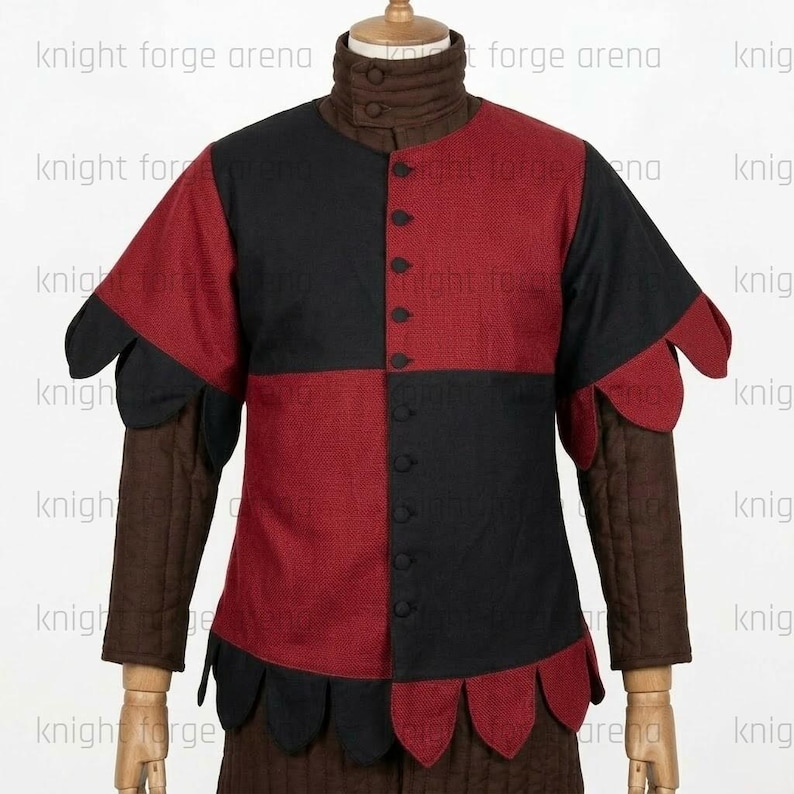 Peut inclure: Un pourpoint pr&eacute;sentant un motif &agrave; damier compos&eacute; de panneaux noirs et rouges sur le torse, des manches longues marron &agrave; texture matelass&eacute;e et un col montant &agrave; deux boutons. Le v&ecirc;tement inclut des d&eacute;tails d'ourlet festonn&eacute; et une fermeture centrale.