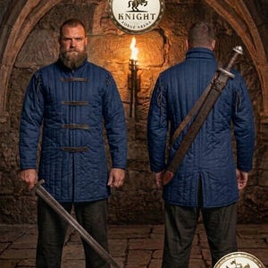 May include: Two men wearing navy blue quilted jackets with leather straps and a long sword. The jackets have a button-up front and are worn with dark pants. The background features a stone archway and a torch. The image includes the text "KNIGHT FORGE ARENA" in a circular logo.