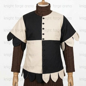 Peut inclure: Un pourpoint pr&eacute;sentant un motif &agrave; damier noir et cr&egrave;me sur le torse avec un col haut et des manches longues marron. Le v&ecirc;tement comprend une rang&eacute;e centrale de boutons et un ourlet festonn&eacute; le long de la taille et des manches courtes.