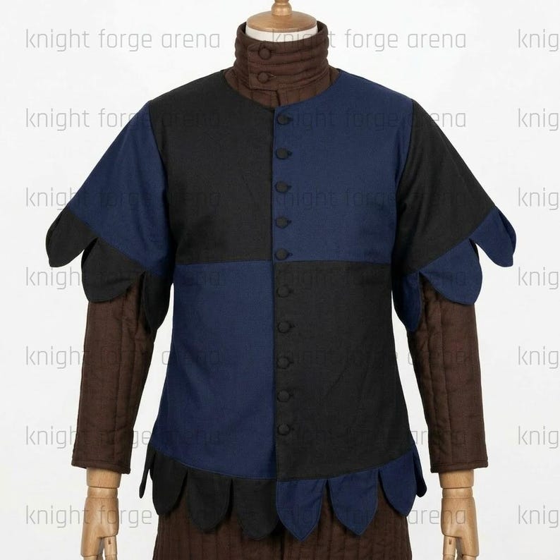 Peut inclure: Un pourpoint avec un corsage &eacute;cartel&eacute; noir et bleu marine, un col montant et des manches longues matelass&eacute;es marron. Le v&ecirc;tement pr&eacute;sente une fermeture boutonn&eacute;e sur le devant et des bords festonn&eacute;s &agrave; la taille et aux &eacute;paules. Texte knight forge arena.