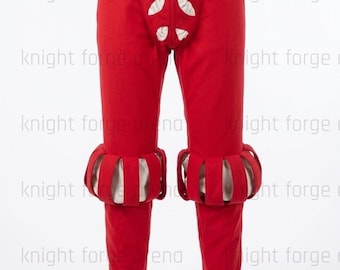 Peut inclure: Pantalon historique rouge avec découpes décoratives et poignets à volants. Le pantalon a une taille haute et est fait d'un tissu rouge uni. Les poignets sont blancs et rouges. Fait partie d'un costume historique.
