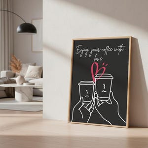Puede incluir: Impresión artística enmarcada con fondo negro. Presenta un dibujo lineal blanco de dos tazas de café sostenidas por manos, con el texto "Enjoy your coffee with love" en escritura blanca y un corazón rosa. El marco es de color marrón claro.