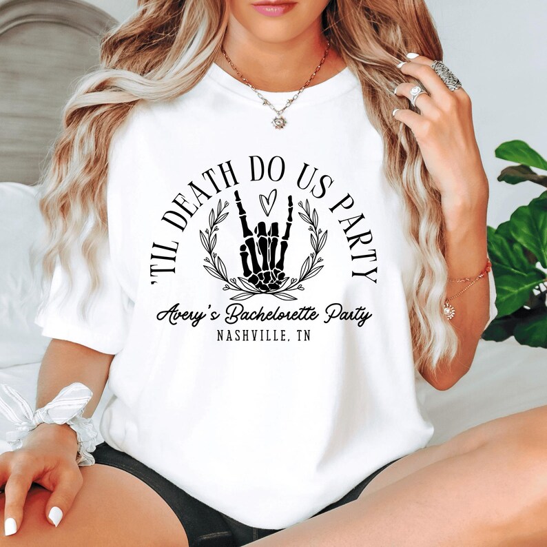 Puede incluir: Camiseta blanca con un gr&aacute;fico negro que dice "Til Death Do Us Party" con una mano de esqueleto haciendo un signo de rock and roll y un coraz&oacute;n. El texto "Avery's Bachelorette Party Nashville, TN" est&aacute; debajo del gr&aacute;fico.