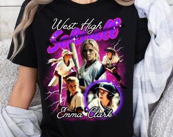 May include: A black t-shirt with a graphic design featuring a collage of female softball players. The text "West High Softball" is in a pink and purple font with a lightning bolt design. The text "Emma Clark" is below the collage.
