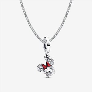 May include: A silver necklace featuring a dangling charm shaped like a mouse head with two clear round stones for ears and a larger clear round stone for the face, accented by a small red enamel bow between the ears on a delicate silver chain.