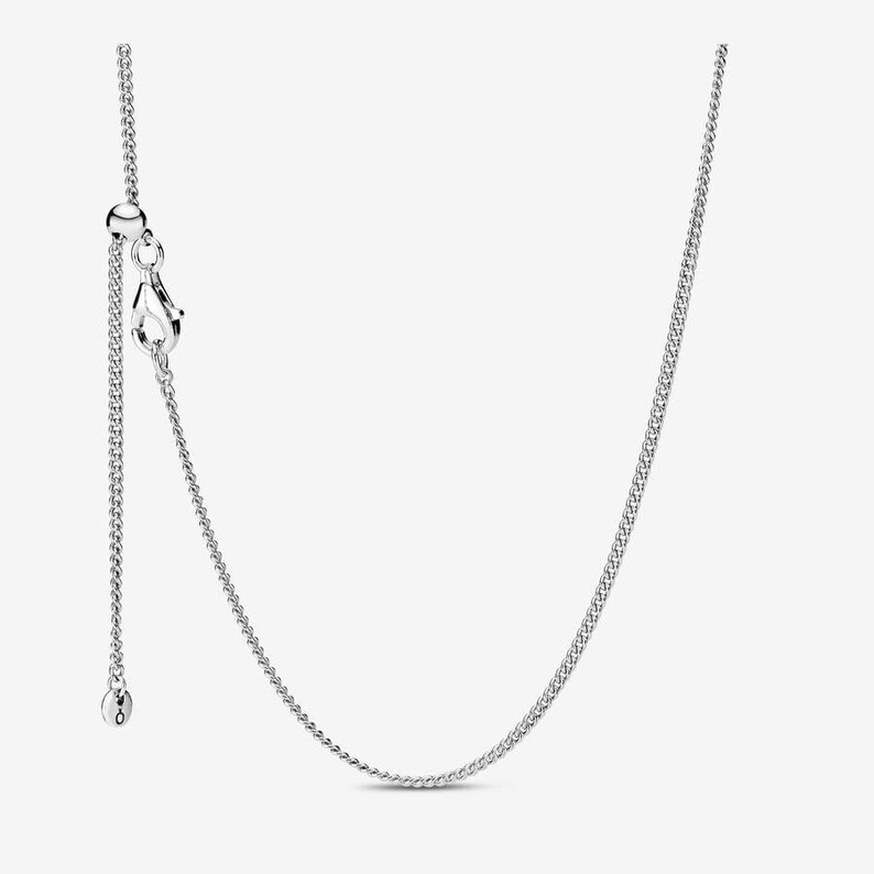 May include: A silver-toned chain necklace featuring a delicate curb link design. The necklace includes an adjustable sliding bead mechanism and a lobster claw clasp, allowing for customizable length adjustments to suit various necklines.