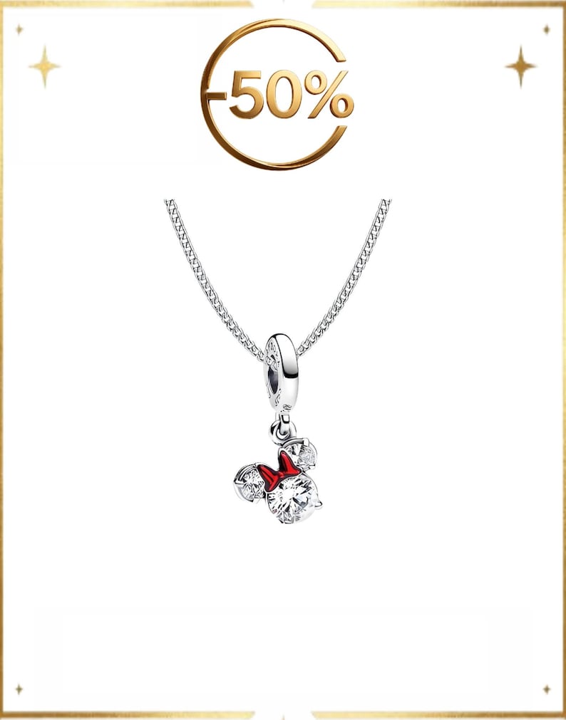 May include: A silver necklace featuring a pendant shaped like a mouse head with two clear round stones for ears and a larger clear round stone for the face, accented by a small red bow. Above the pendant, the text -50% is displayed in gold.
