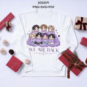 May include: White crewneck sweatshirt featuring a cartoon illustration of seven figures in purple outfits on a cloud. The text "WE ARE BACK" is below the illustration, with "Arirang World Tour 2026" underneath. The sweatshirt is surrounded by wrapped gifts.