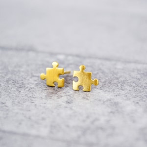 May include: A pair of gold-toned puzzle piece shaped stud earrings.