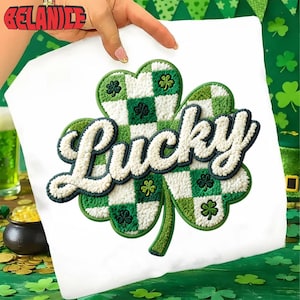 Op de afbeelding: Wit St. Patrick's Day-shirt met een groot, geborduurd klaverontwerp. De klaver heeft een groen-wit geblokt patroon met het woord "Lucky" in een zacht, gebroken witte letter.