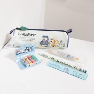 May include: A white pencil case with a dark blue zip and a green leaf pull, featuring PataPataPeppy characters. Included are a pack of four small coloured glue sticks, a white ballpoint pen, a light green HB pencil, and a blue plastic ruler.