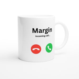 May include: White ceramic mug with the word "Margin" in black, and the phrase "Incoming call..." below it. Features a red phone hang-up icon and a green phone receiver icon. A humorous design for a coffee mug.
