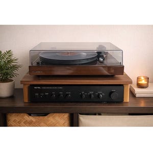 Peut inclure: Une platine vinyle en bois avec un couvercle transparent est posée sur un support en bois. En dessous, un amplificateur stéréo noir. Le mot "Fluance" est visible sur la platine.
