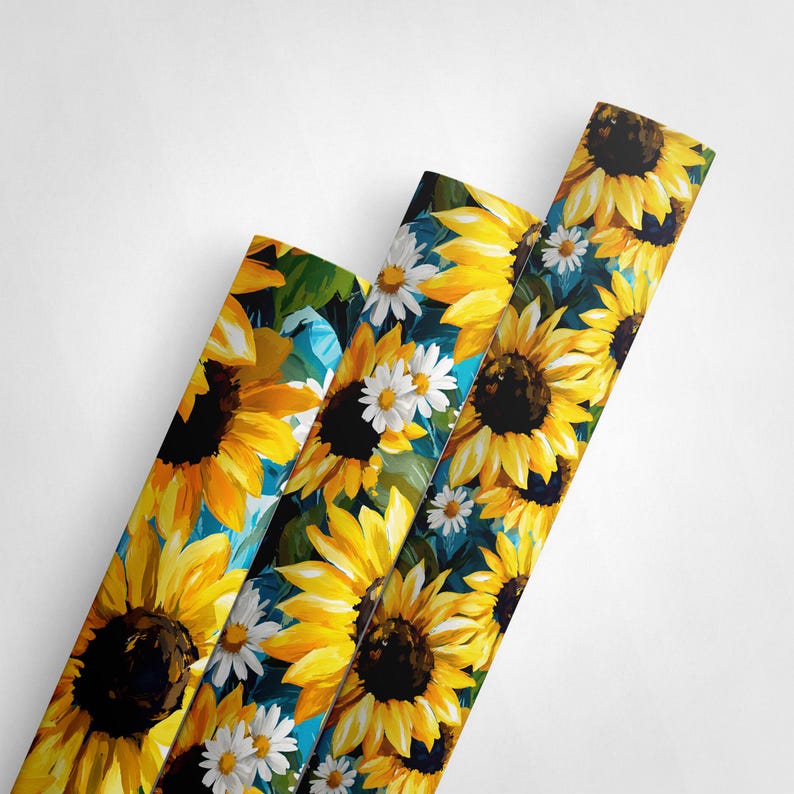 May include: Three rolls of floral wrapping paper featuring a vibrant sunflower and daisy design. The sunflowers have bright yellow petals and dark brown centers, while the daisies have white petals and yellow centers. The background is a mix of blue and green.