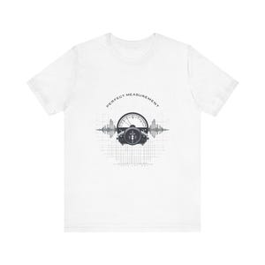 Puede incluir: Camiseta blanca con un diseño gráfico que presenta un medidor y las palabras "PERFECT MEASUREMENT" encima. El diseño incluye un fondo de cuadrícula y patrones de ondas a ambos lados del medidor.