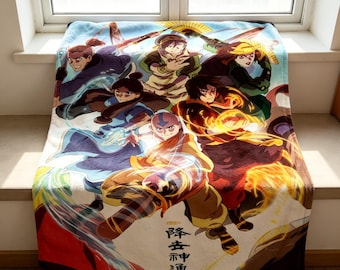 以下が含まれることがあります： アニメシリーズのキャラクターのカラフルなイラストが描かれた、柔らかいブランケット。さまざまなアクションポーズの人物が、青と白の背景に描かれています。ブランケットの下部には日本語のテキストがあります。