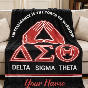 Könnte beinhalten: Schwarze Fleece-Decke mit roten und weißen Grafiken. Die Decke zeigt den Text "INTELLIGENCE IS THE TORCH OF WISDOM" und "DELTA SIGMA THETA". Ein Platz für einen Namen in roter Schrift ist vorgesehen.