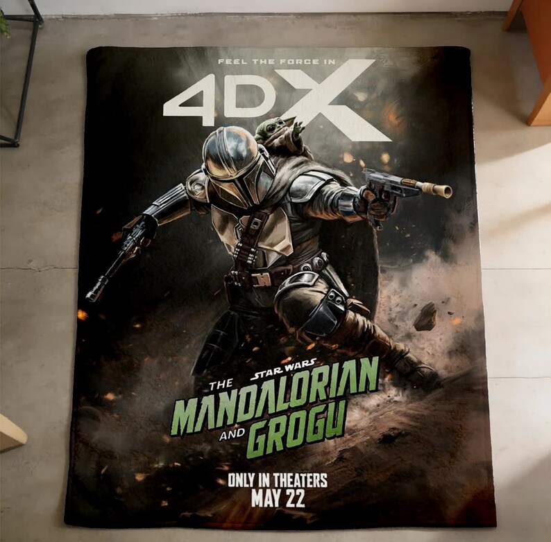 May include: A rectangular blanket featuring a Star Wars design. The image shows The Mandalorian and Grogu in action, with the text "The Mandalorian and Grogu" and "Only in Theaters May 22". The blanket has a dark background with the text "Feel the Force in 4DX".