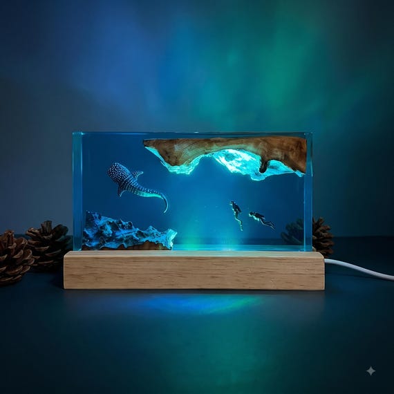 A whale shark and scuba diver suspended in glowing epoxy resin — a full underwater diorama you can leave on your desk.