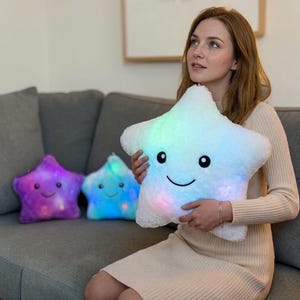 May include: A white ceramic mug with a black handle and the text "But First, Coffee" in a black, handwritten-style font. The mug is on a white surface.