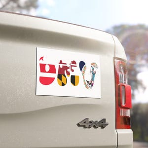 May include: A rectangular white bumper sticker featuring the letters O, M, and V. The O is red and white, the M is a Maryland flag puzzle piece, and the V is a Virginia state flag design with the state seal and the Latin text Sic Semper Tyrannis.