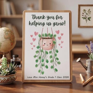 May include: A wooden framed print with the text "Thank you for helping us grow!" features a watercolor illustration of a smiling pink plant pot with hanging vines and heart accents. The print is a teacher appreciation gift.