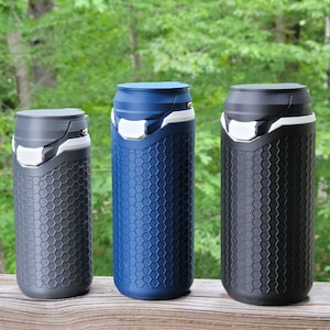 May include: Three cylindrical beverage containers with a textured honeycomb pattern on the exterior. The containers are dark gray, blue, and black, each featuring a matching lid with a white accent piece and a metallic silver latch mechanism.