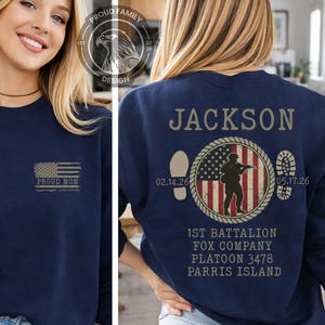 May include: Navy blue sweatshirt with "PROUD MOM" and an American flag graphic on the front. The back features the name "JACKSON", a soldier silhouette, dates, and military unit details. A patriotic themed apparel item.