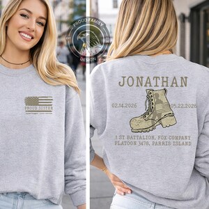 May include: A light gray sweatshirt with the text "PROUD SISTER" and an American flag design on the front. The back of the sweatshirt features the name "JONATHAN", a military boot graphic, and text indicating military service.