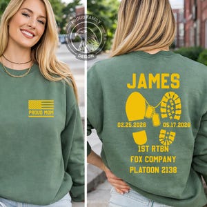 May include: Green sweatshirt with a yellow American flag and the words "PROUD MOM" on the front. The back features the name "JAMES", dates, dog tags, boot prints, and unit information in yellow. A Proud Family Design logo is visible.