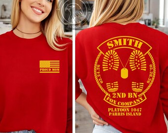 May include: Red sweatshirt with a yellow American flag and the text "PROUD MOM" on the front. The back features the name "SMITH", military insignia, and text including "2ND BN FOX COMPANY" and "PLATOON 1047 PARRIS ISLAND".