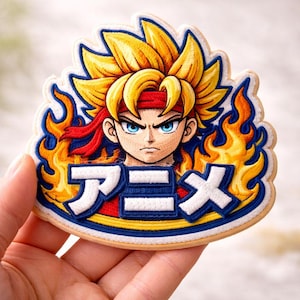 May include: Embroidered patch depicting an anime character with spiky yellow hair and a red headband, framed by flames. The Japanese word "Anime" is written in white with blue borders.