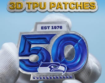 May include: A custom 3D TPU patch with the text "CUSTOM 3D TPU PATCHES". The patch features a blue and silver design with the number "50" and the text "EST 1976". The patch also includes a logo of a bird.