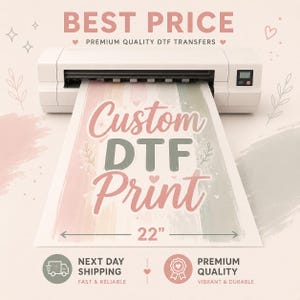 May include: A white digital printer outputting a sheet with the text Custom DTF Print in pink and sage green. The sheet features a 22-inch width indicator and soft watercolor-style vertical stripes in pink, sage green, and cream with small heart icons.