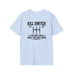May include: Light blue t-shirt with a black graphic. The graphic includes the words "KILL SWITCH" above a gear shift pattern with the numbers 1, 2, 3, 4, 5, and R. Below the gear shift, the text reads "YOU CAN'T STEAL WHAT YOU CAN'T DRIVE."