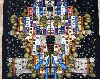 Puede incluir: Un pañuelo cuadrado negro con un estampado arquitectónico simétrico y colorido de edificios estilizados con fachadas azules, amarillas y rojas, árboles verdes y puntos dispersos. El texto "HUNDERTWASSER" y "MEN" es visible en la parte superior.
