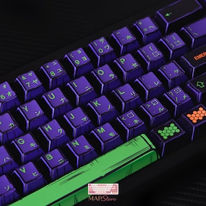 Puede incluir: Un teclado mecánico personalizado con teclas moradas que presentan caracteres japoneses y letras inglesas. Las teclas tienen una base morada con letras blancas y detalles en verde. El teclado tiene una barra espaciadora verde y un marco negro.