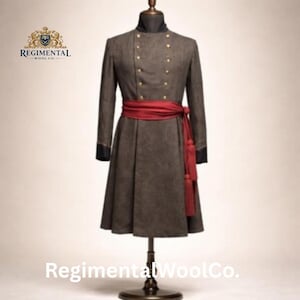 May include: A brown wool coat with gold buttons and a red sash. The coat has long sleeves and a flared skirt. The coat is displayed on a mannequin. The text "Regimental Wool Co." is visible.