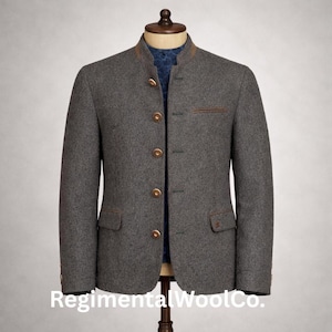 May include: A grey wool jacket with a mandarin collar and brown trim. The jacket features four gold buttons and two small pockets. The text "Regimental WoolCo." is visible at the bottom of the image.