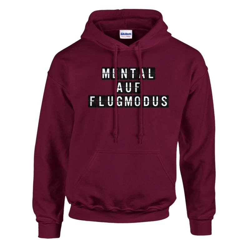 Op de afbeelding: Een bordeauxrode hoodie met de tekst "MENTAL AUF FLUGMODUS" in witte blokletters. De hoodie heeft een capuchon met trekkoord en een voorzak. De merknaam "Gildan" is zichtbaar.