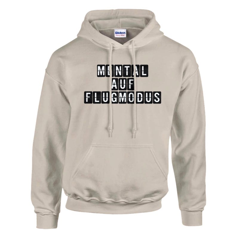 Op de afbeelding: Een lichtbeige hoodie met een capuchon met trekkoord en een kangoeroezak. De voorkant van de hoodie heeft de tekst "MENTAL AUF FLUGMODUS" in zwarte blokletters. De hoodie is gemaakt van een zacht, comfortabel materiaal.