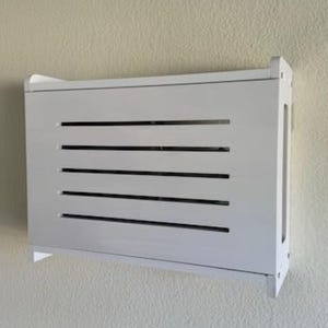 Puede incluir: Un mueble blanco rectangular montado en la pared con listones horizontales. El mueble est&aacute; montado en una pared texturizada de color claro. El nombre de la marca "ZivlynDesigns" es visible en la esquina superior izquierda e inferior derecha.