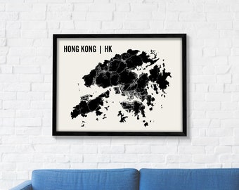 May include: A black and white map print of Hong Kong with the text "HONG KONG | HK" at the top. The map is framed in a black frame and is hanging on a white brick wall above a blue couch.