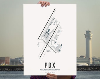 May include: A white poster with a black and gray diagram of the Portland International Airport (PDX) layout. The poster has the text "PDX" and "PORTLAND INTERNATIONAL AIRPORT" in black.