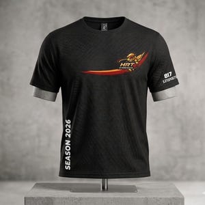 May include: Black short-sleeved t-shirt with a double-layered sleeve design. The shirt features a logo with the text "HRT LE MANS RACING" and a stylized figure. The text "SEASON 2026" is printed vertically on the side, and "817 S. D'ESPOSITO" is on the sleeve.